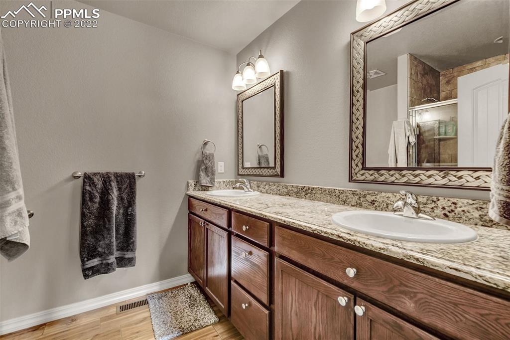 6570 Gelbvieh Road Peyton, CO 80831 - Photo 24 of 38 a bathroom with double vanity and a mirror