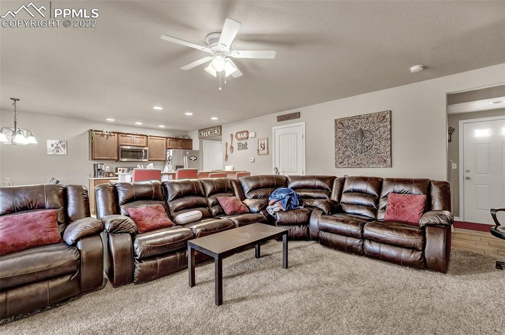 6570 Gelbvieh Road Peyton, CO 80831 - Photo 4 of 38 a living room with furniture and a chandelier