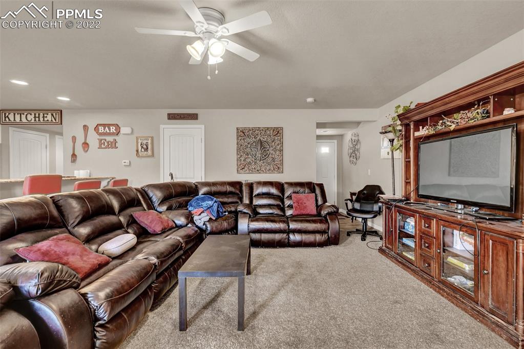 6570 Gelbvieh Road Peyton, CO 80831 - Photo 5 of 38 a living room with furniture and a flat screen tv