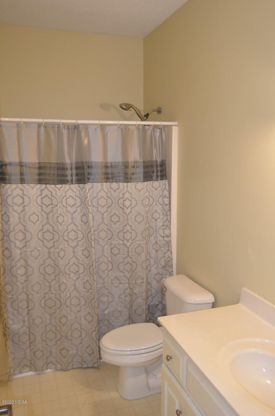 253 Chadwick Circle Macon, GA 31210 - Photo 19 of 19 a bathroom with a granite countertop toilet and a sink