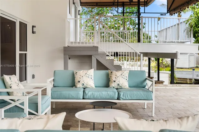 a view of a patio with couches table and chairs with wooden floor