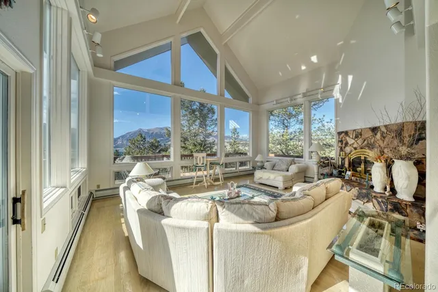 a living room with fireplace furniture and a large window