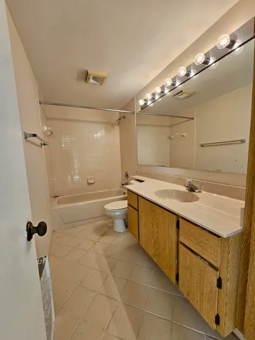 a bathroom with a granite countertop sink a toilet a mirror and shower