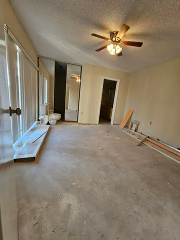 an empty room with closet and a ceiling fan