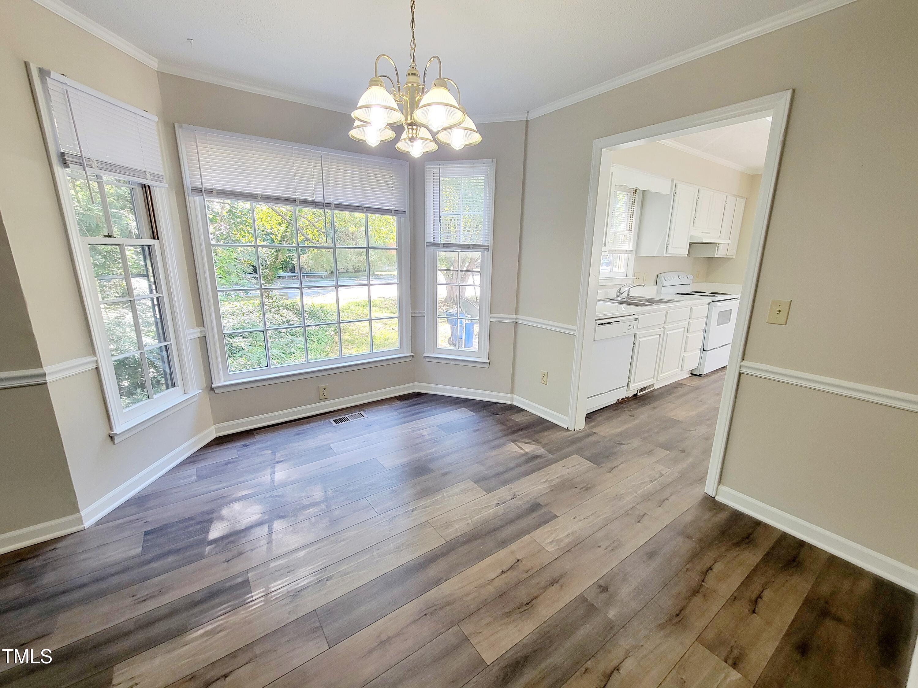 500 Brent Road, Unit 101 Raleigh, NC 27606 - Photo 16 of 62 a view of an empty room with wooden floor and a window