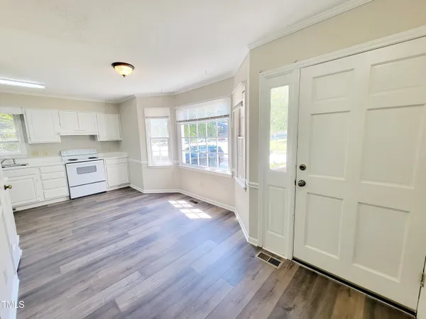 a view of a kitchen with wooden floor and a window