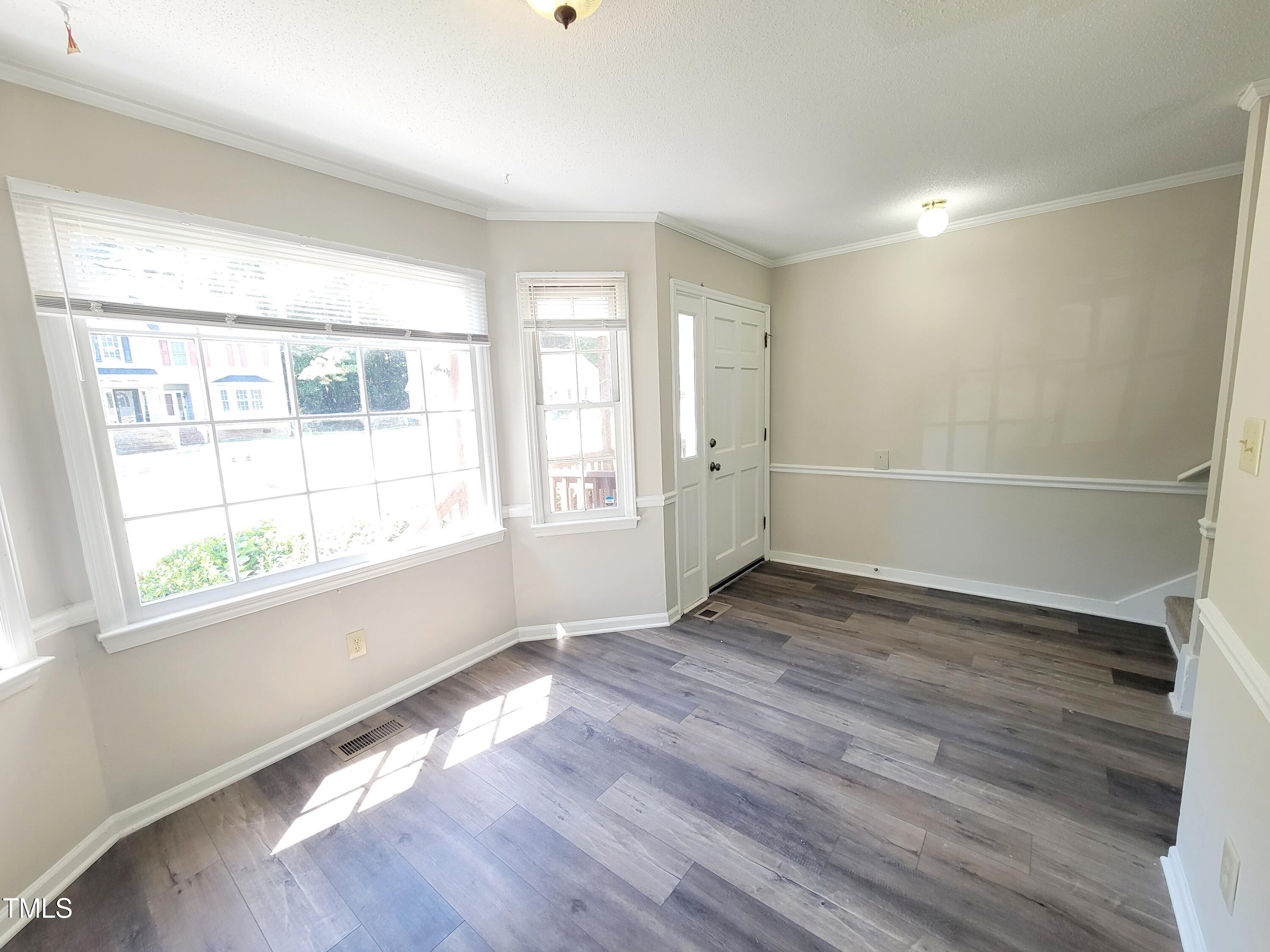 500 Brent Road, Unit 101 Raleigh, NC 27606 - Photo 5 of 62 an empty room with wooden floor and windows