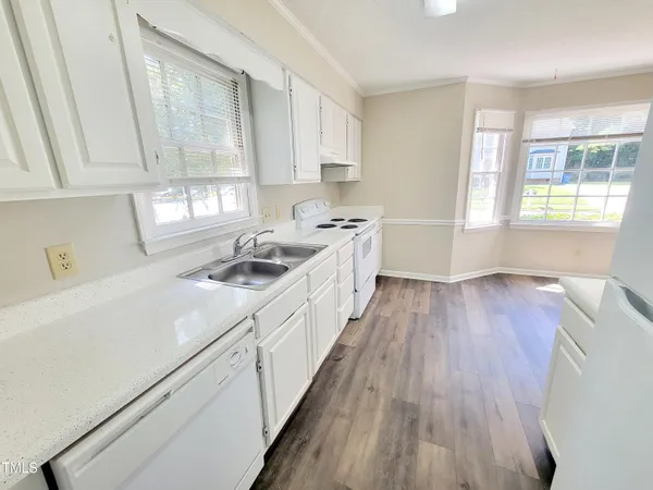 a kitchen with a sink a wooden floor and cabinets