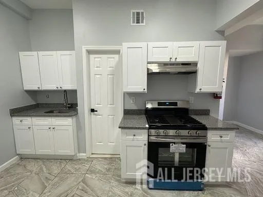 a kitchen with stainless steel appliances a stove a sink and a refrigerator