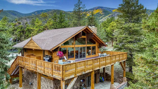 a front view of a house with yard and mountain view in back
