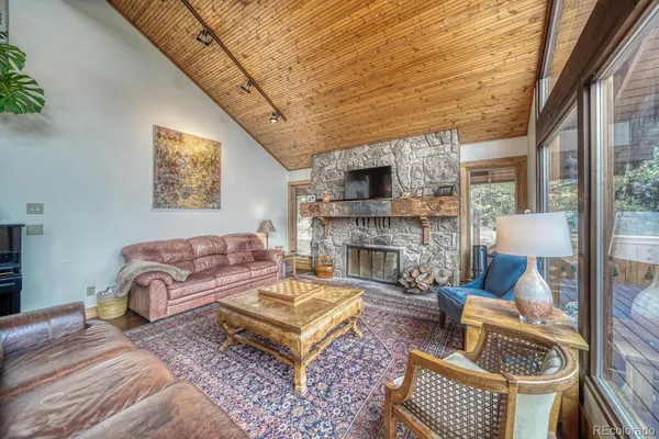 a living room with furniture a fireplace and a large window