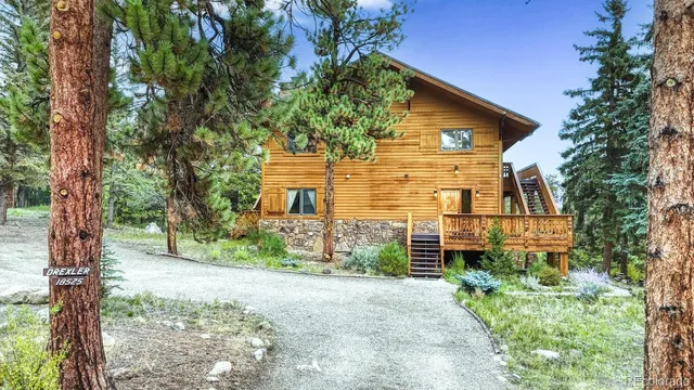 a front view of a house with a tree