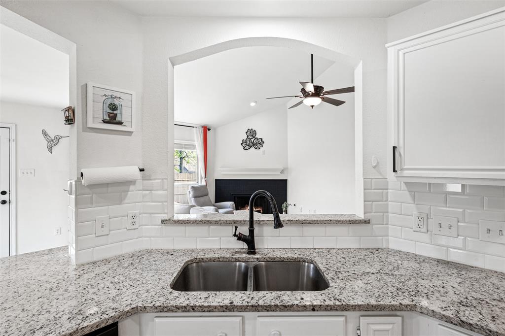 1011 Ridgecrest Drive McKinney, TX 75069 - Photo 16 of 31 Kitchen with granite countertops, stainless steel sink, black faucet, and white subway tile backsplash