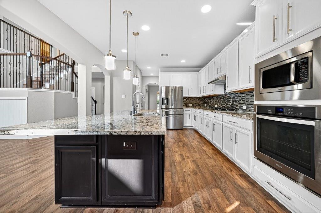 5710 Metaphor Way Richmond, TX 77469 - Photo 14 of 41 The kitchen is a space of gathering and creation — bright cabinetry, cool granite, and pendant lighting surrounding an island large enough to serve as both prep station and conversation hub.
