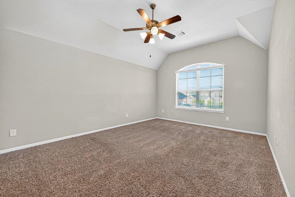 5710 Metaphor Way Richmond, TX 77469 - Photo 35 of 41 Spacious and serene, this bedroom features a wide arched window and carpeting for comfort.