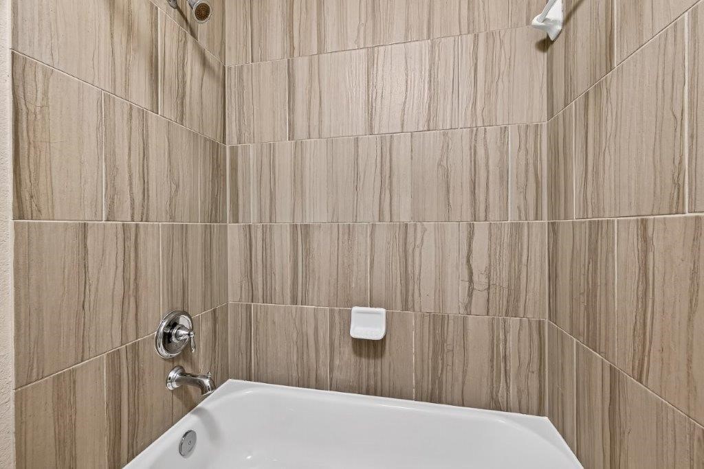 5710 Metaphor Way Richmond, TX 77469 - Photo 38 of 41 Another full bath includes a tub-shower combination framed by coordinating tile work.