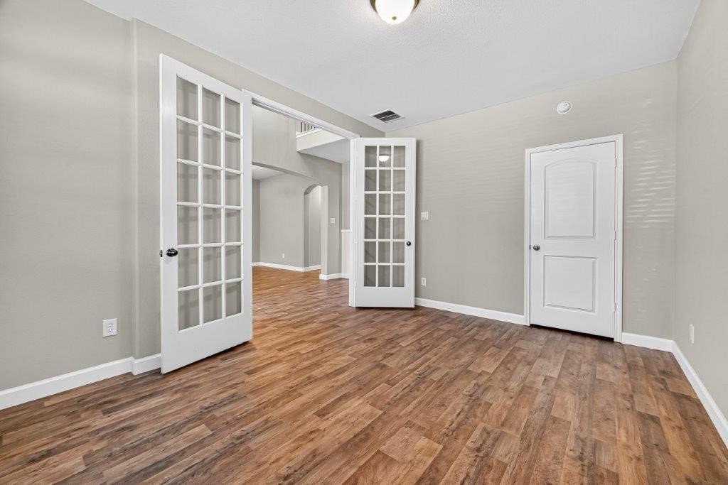 5710 Metaphor Way Richmond, TX 77469 - Photo 9 of 41 Through double French doors, the office offers a quiet retreat, where warm wood flooring and abundant light create an ideal workspace.