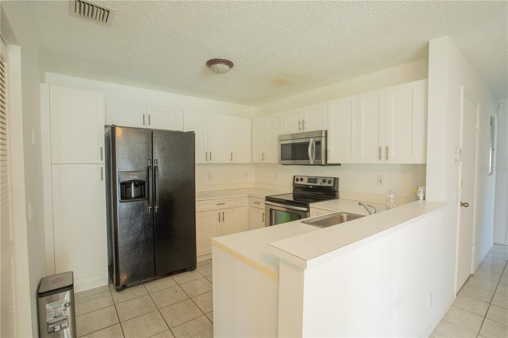 1711 Southwest 116th Way Miramar, FL 33025 - Photo 12 of 33 a kitchen with a refrigerator sink and cabinets