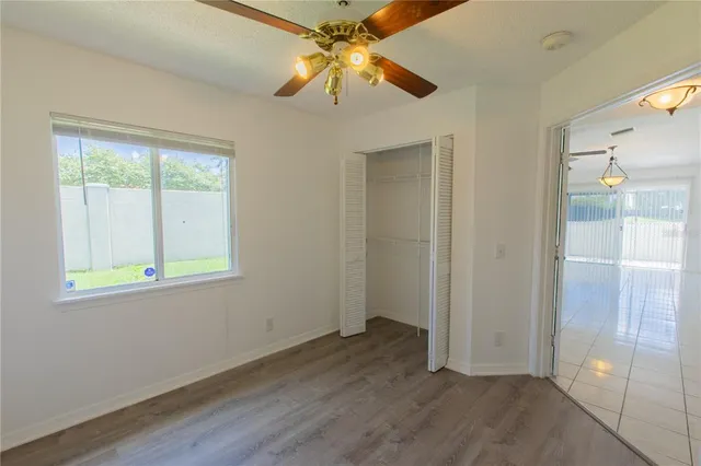 an empty room with a window and a fan