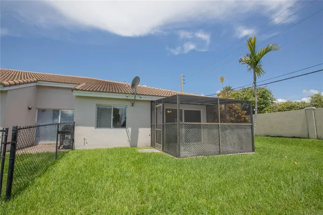 a view of a house with a big yard and potted plants