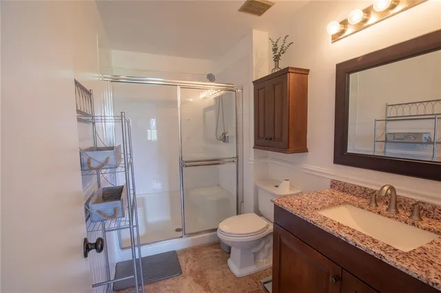 a bathroom with a granite countertop sink toilet and shower