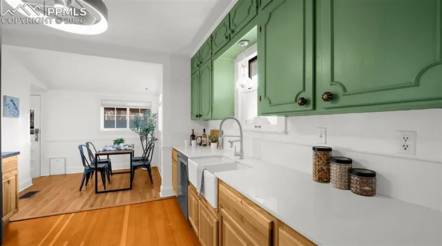 a kitchen with stainless steel appliances wooden floor sink and cabinets