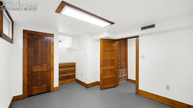 a view of an empty room with closet and a window