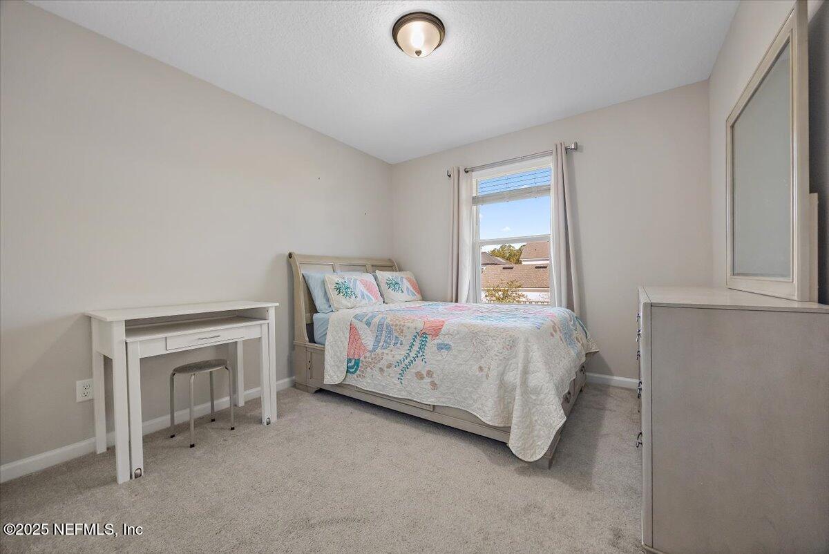 156 Clarys Run St. Augustine, FL 32092 - Photo 17 of 20 a bedroom with a bed and a fireplace