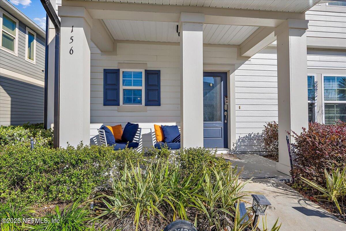 156 Clarys Run St. Augustine, FL 32092 - Photo 3 of 20 a front view of a house with brick walls and potted plants