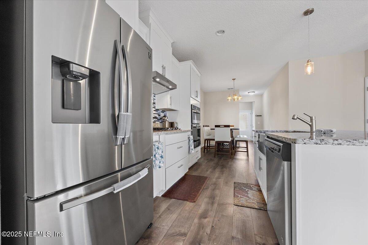 156 Clarys Run St. Augustine, FL 32092 - Photo 6 of 20 a view of a kitchen with refrigerator and wooden floor