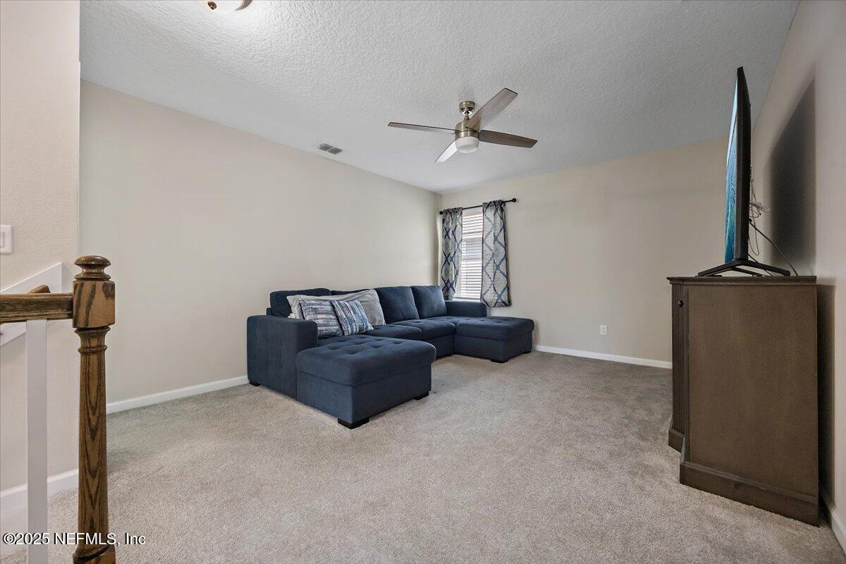 156 Clarys Run St. Augustine, FL 32092 - Photo 10 of 20 a living room with furniture a flat screen tv and a ceiling fan