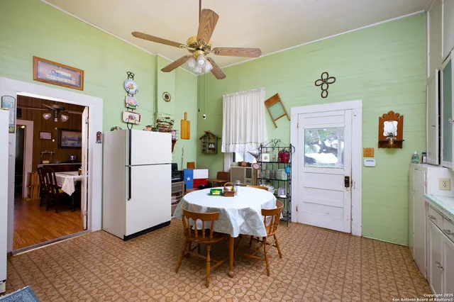 a kitchen with granite countertop a stove a sink dining table and chairs