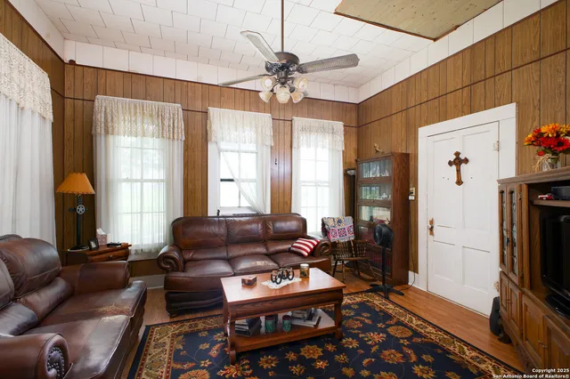 a living room with furniture a dining table and chairs with wooden floor