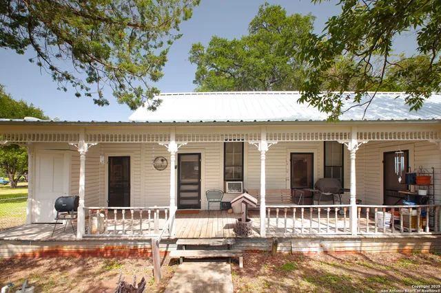 front view of a house with a large tree