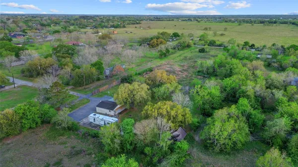 an aerial view of green landscape with trees houses and lake view