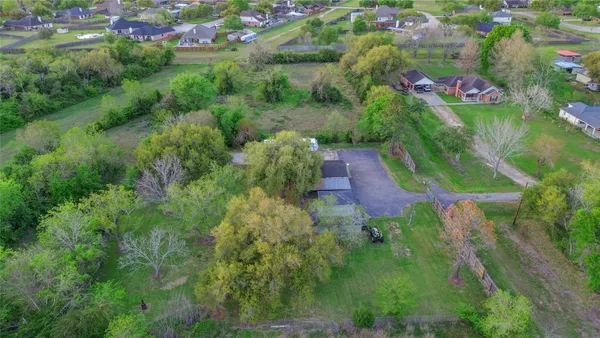an aerial view of residential house with outdoor space and trees all around