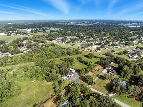 an aerial view of residential houses with outdoor space and trees