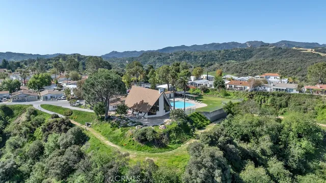 an aerial view of residential house with outdoor space and trees all around