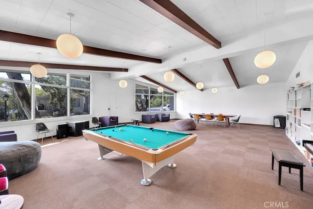 a living room with pool table and a large window