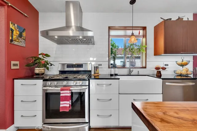 a kitchen with stainless steel appliances granite countertop a stove a sink and a wooden floors