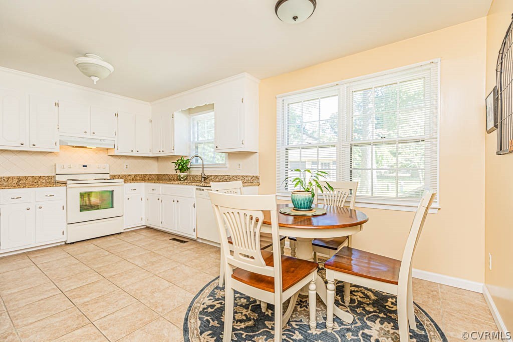 10801 Belvoir Road Chester, VA 23831 - Photo 6 of 23 a kitchen with a dining table chairs and white cabinets