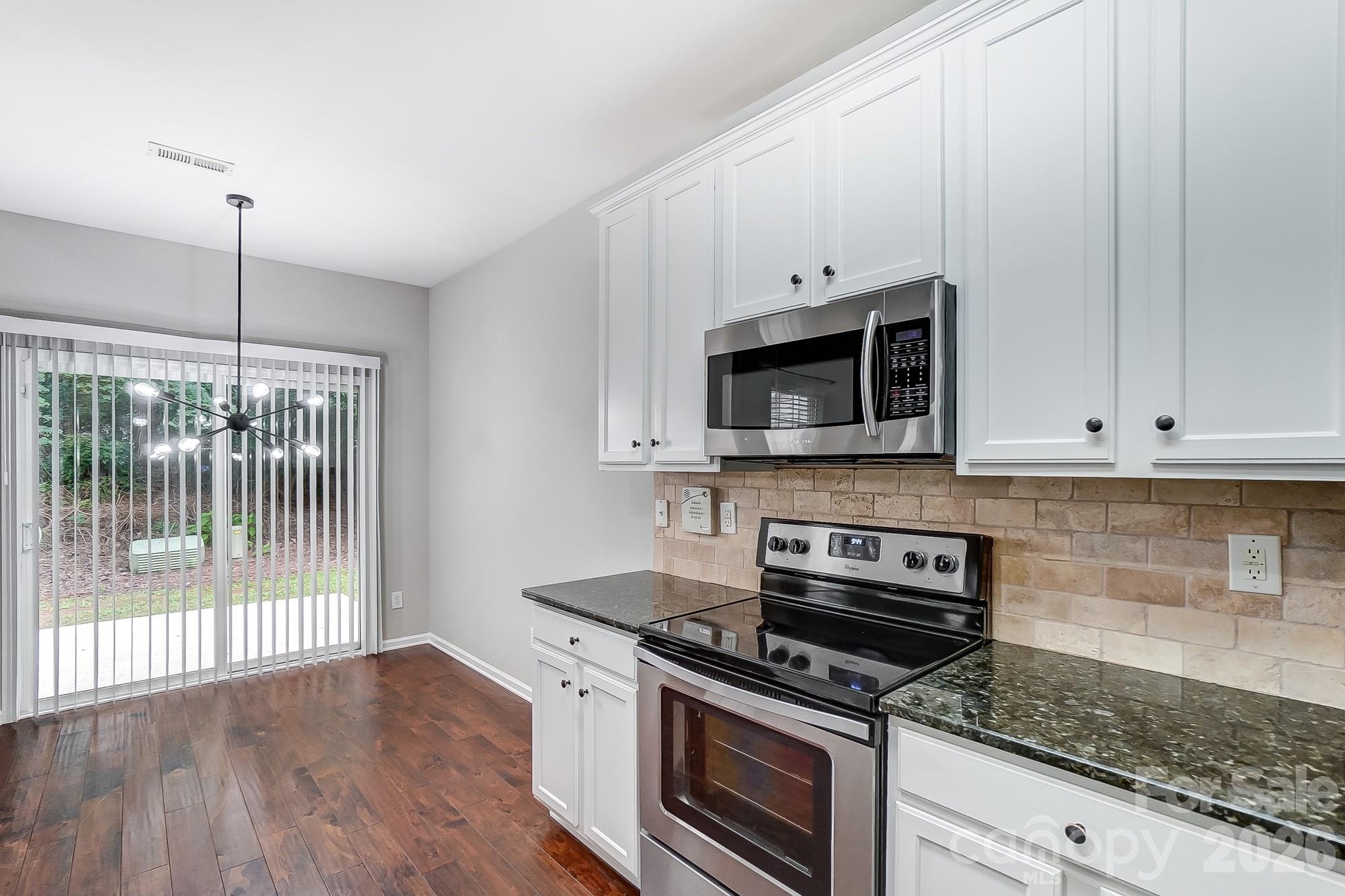 4914 Sunset Ridge Court Charlotte, NC 28269 - Photo 12 of 48 a kitchen with granite countertop a stove and a microwave