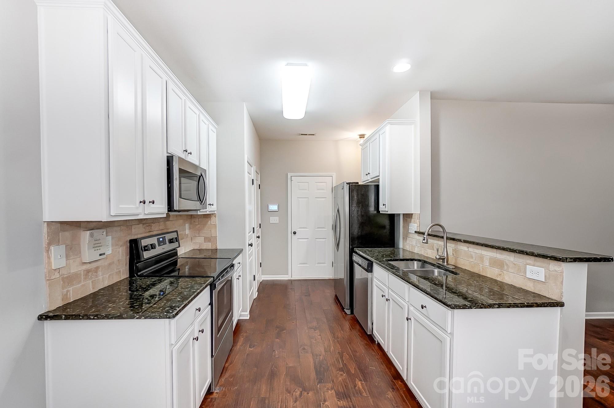4914 Sunset Ridge Court Charlotte, NC 28269 - Photo 13 of 48 a large kitchen with stainless steel appliances granite countertop a stove a sink and a refrigerator