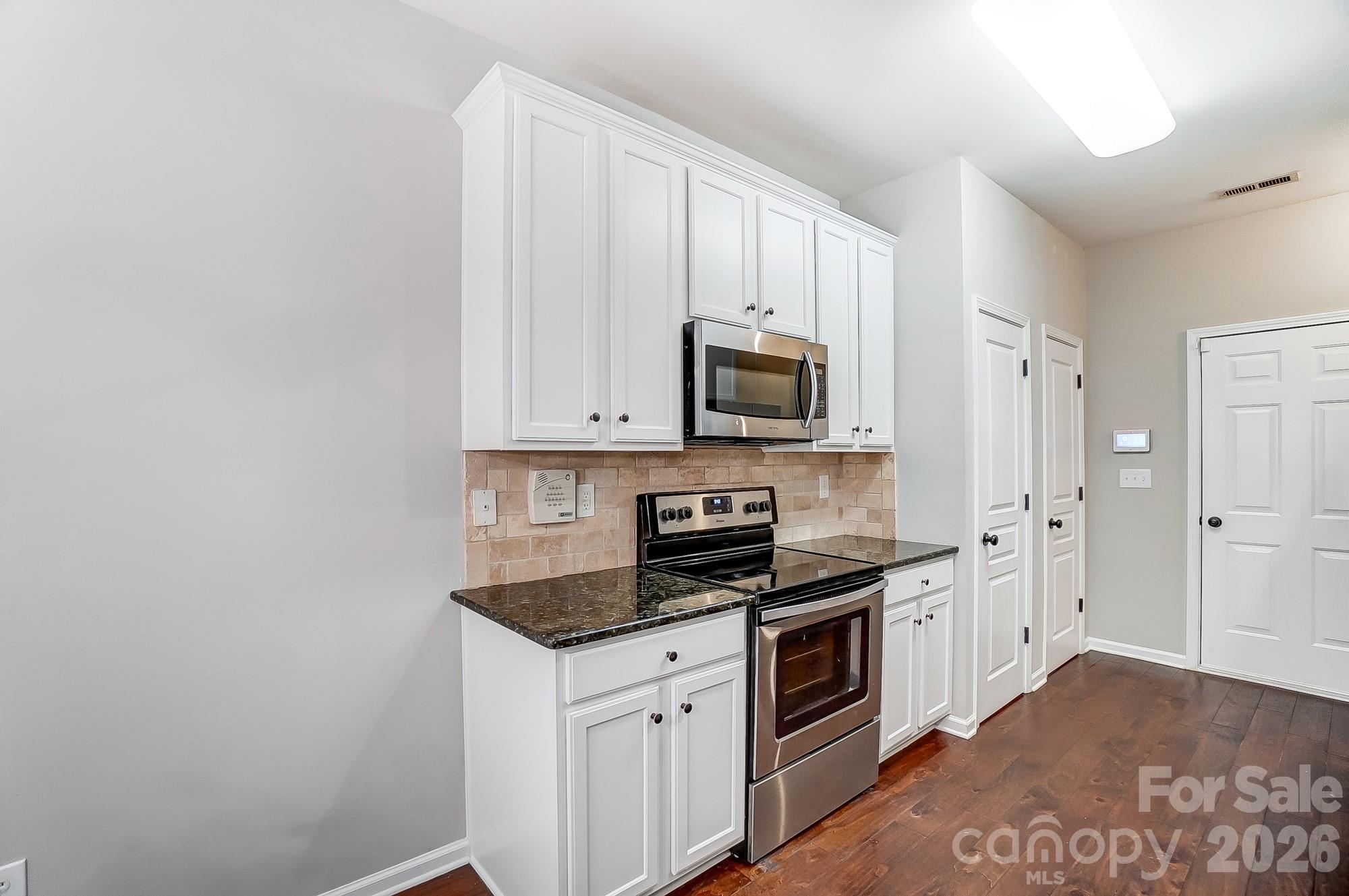 4914 Sunset Ridge Court Charlotte, NC 28269 - Photo 14 of 48 a kitchen with stainless steel appliances granite countertop a stove a sink and a microwave