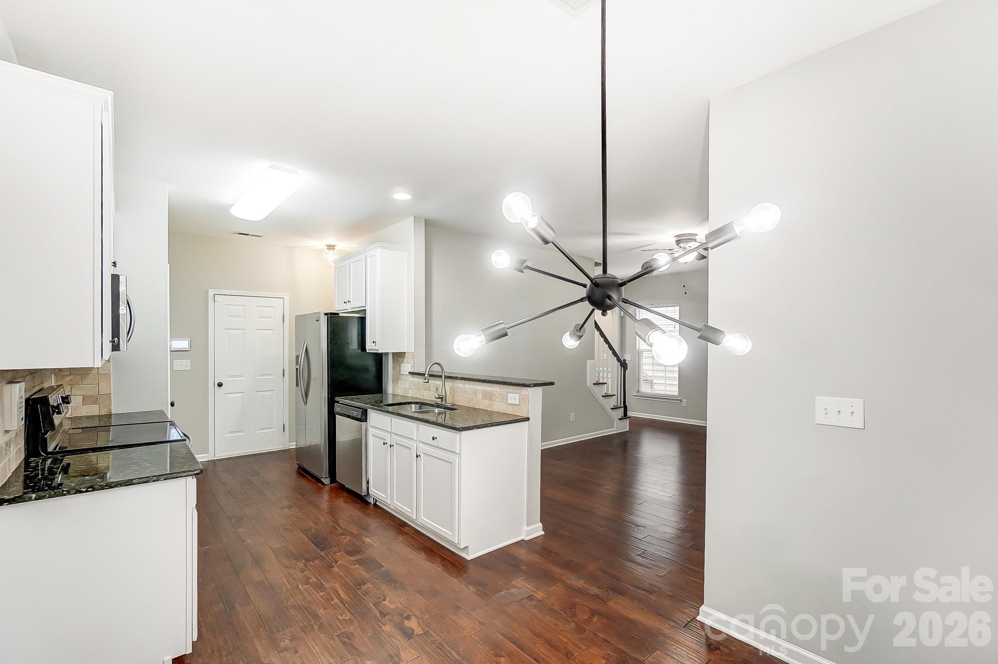 4914 Sunset Ridge Court Charlotte, NC 28269 - Photo 17 of 48 a kitchen with stainless steel appliances kitchen island a stove and a chandelier