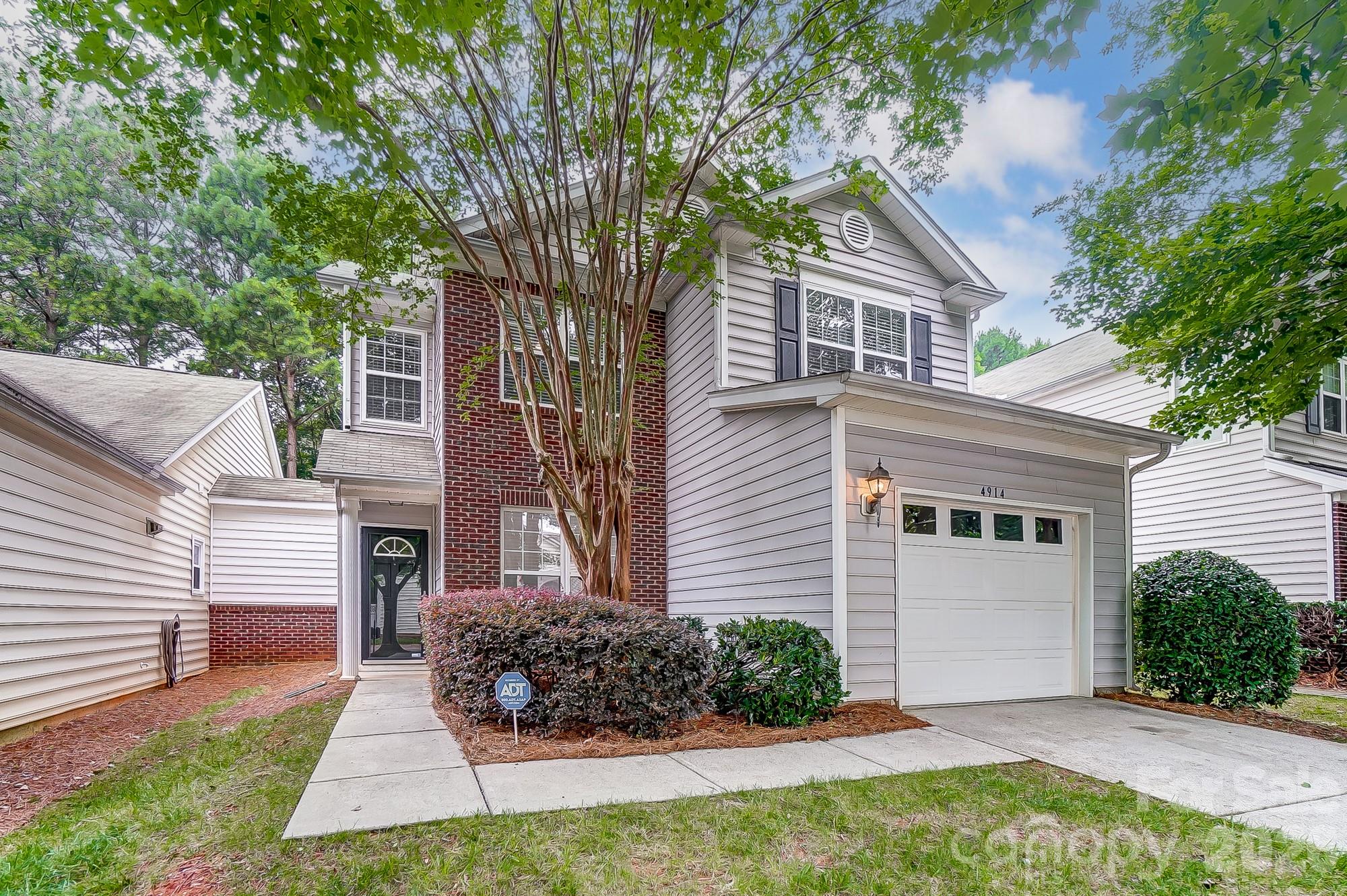 4914 Sunset Ridge Court Charlotte, NC 28269 - Photo 2 of 48 a front view of a house with a yard and potted plants