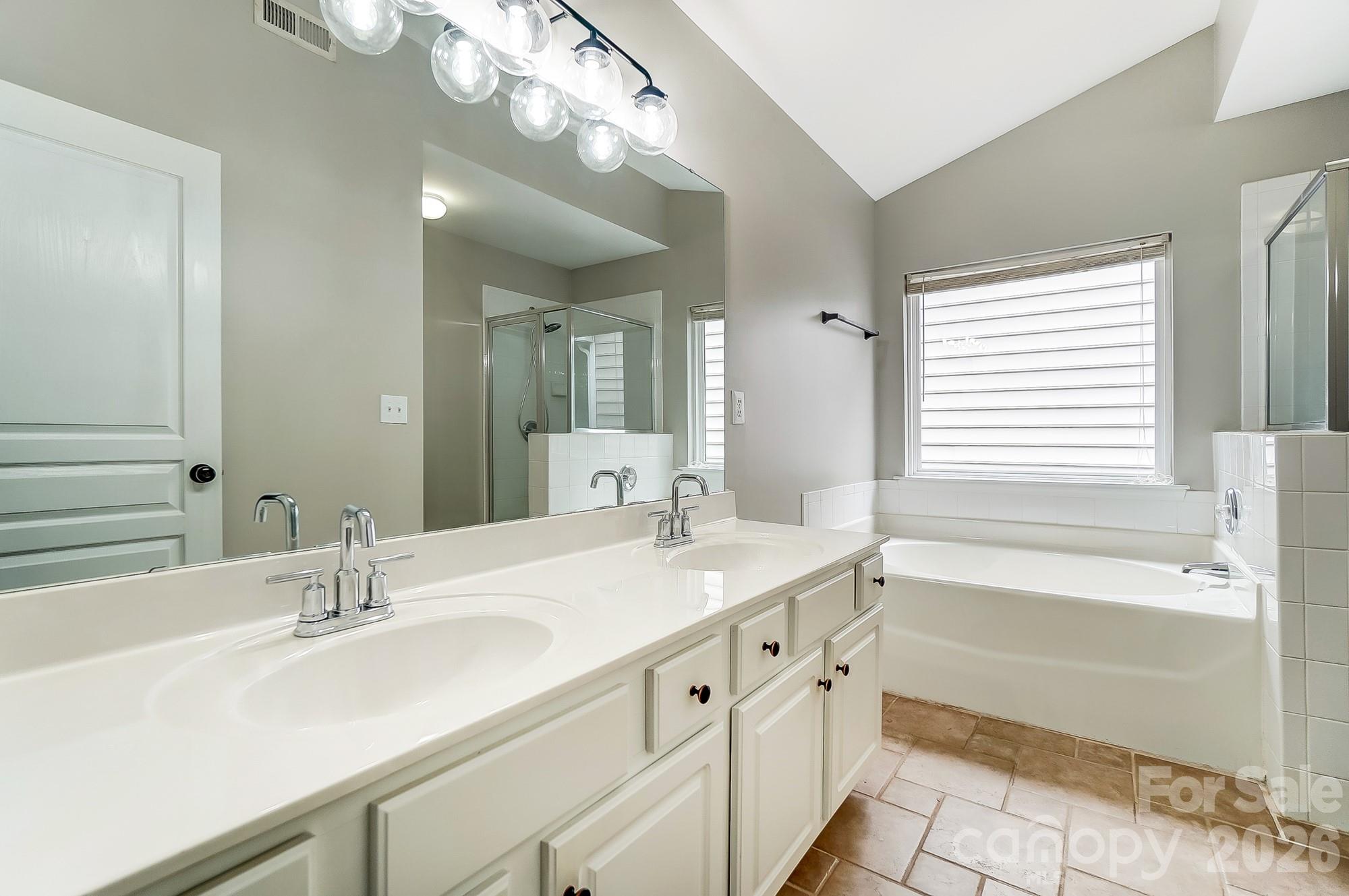 4914 Sunset Ridge Court Charlotte, NC 28269 - Photo 28 of 48 a bathroom with a sink double vanity granite tub shower and a mirror