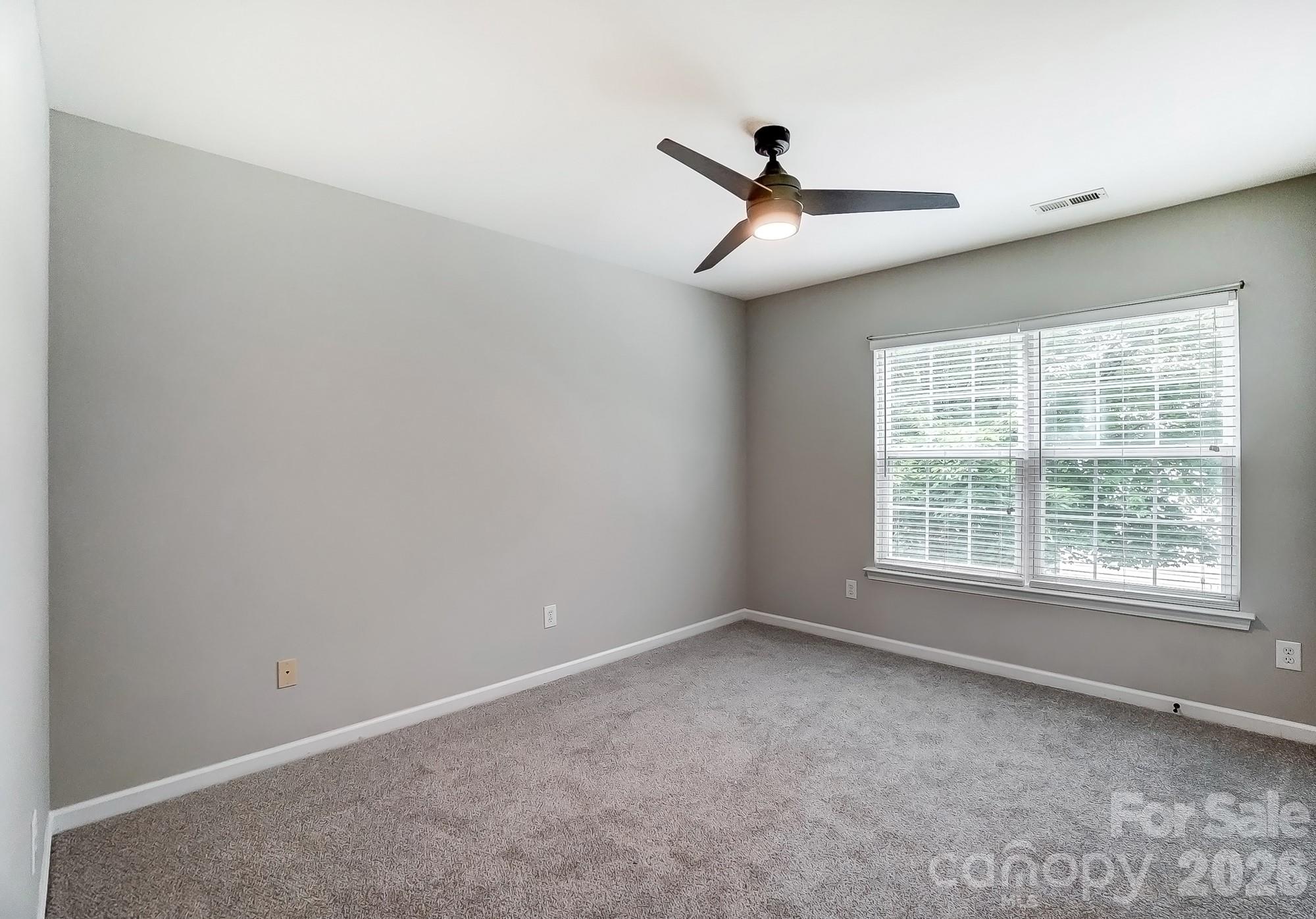 4914 Sunset Ridge Court Charlotte, NC 28269 - Photo 35 of 48 an empty room with a window and a fan