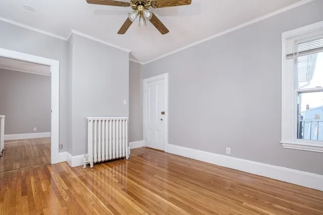 a view of a room with wooden floor fan and windows