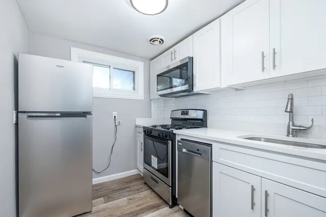 a kitchen with stainless steel appliances a stove a refrigerator a sink and cabinets